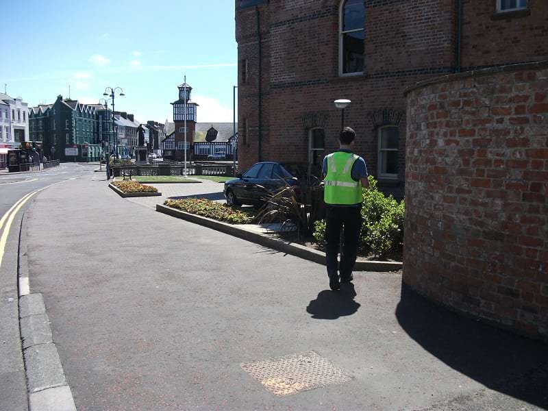 Photograph shows our surveyor beautiful sunny day with RTK GPS collecting existing features onsite on a large Streetscape Project in centre of Portrush for our Client Paul Hogarth